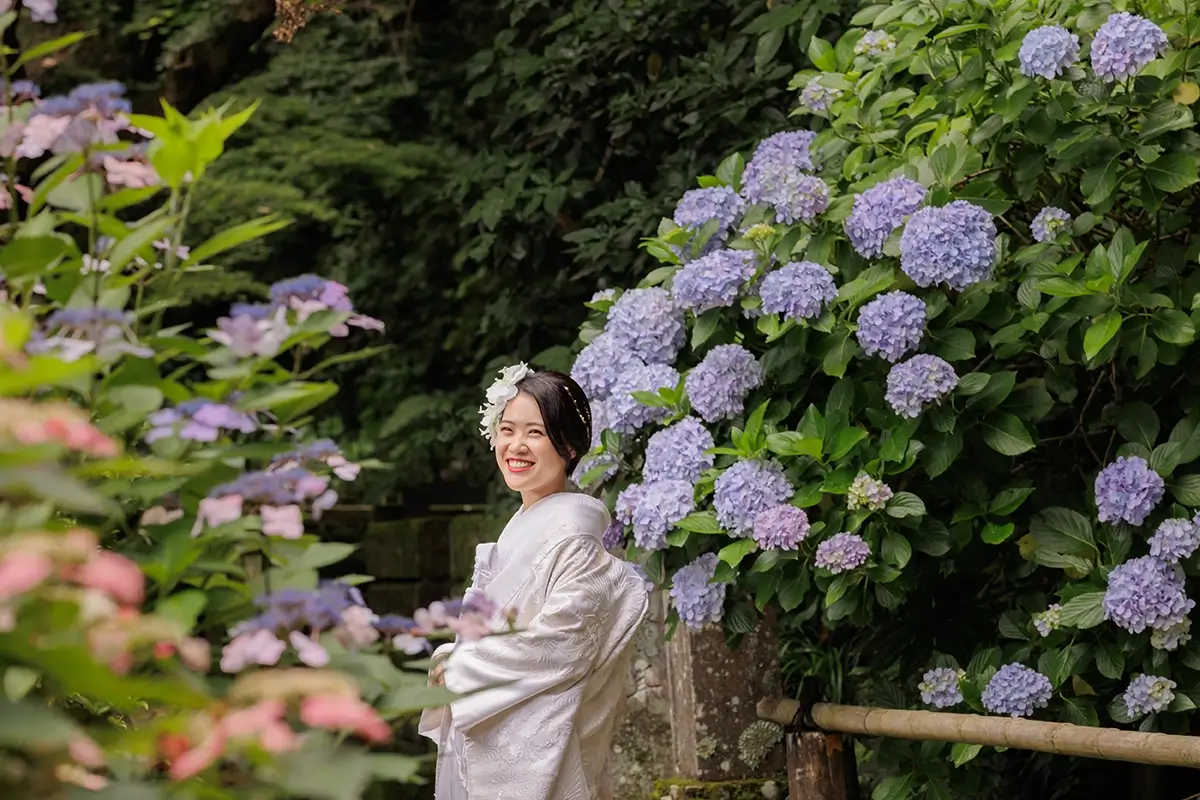 紫陽花の前で微笑んでいるショートカットの女性