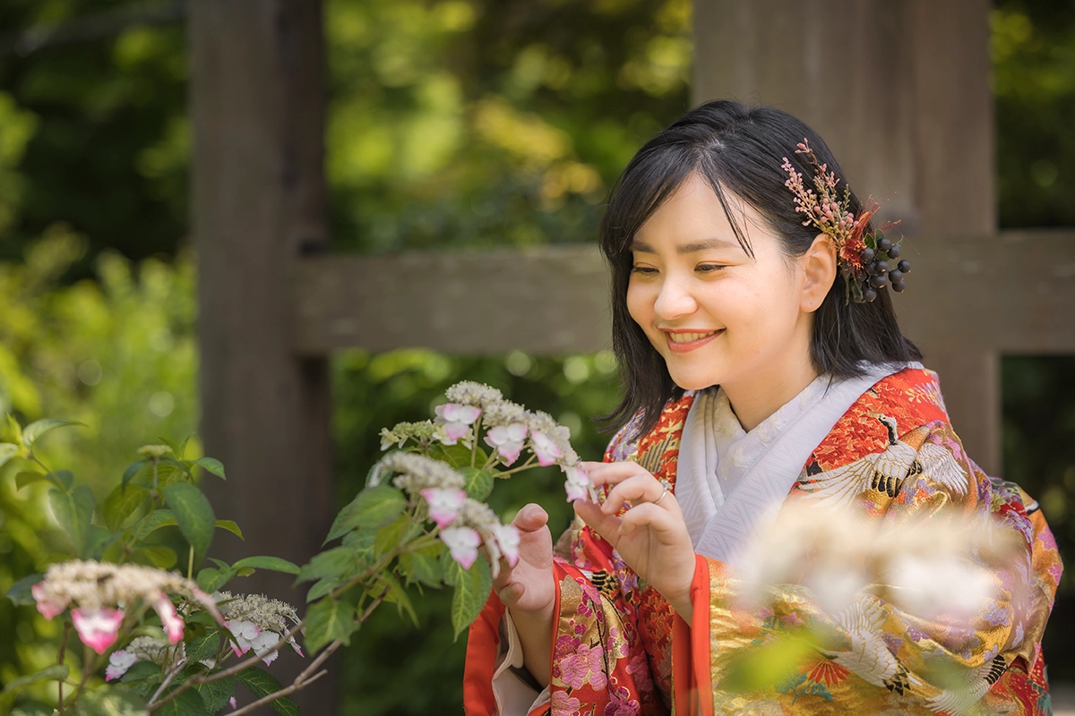 紫陽花の前で微笑んでいるショートカットの女性
