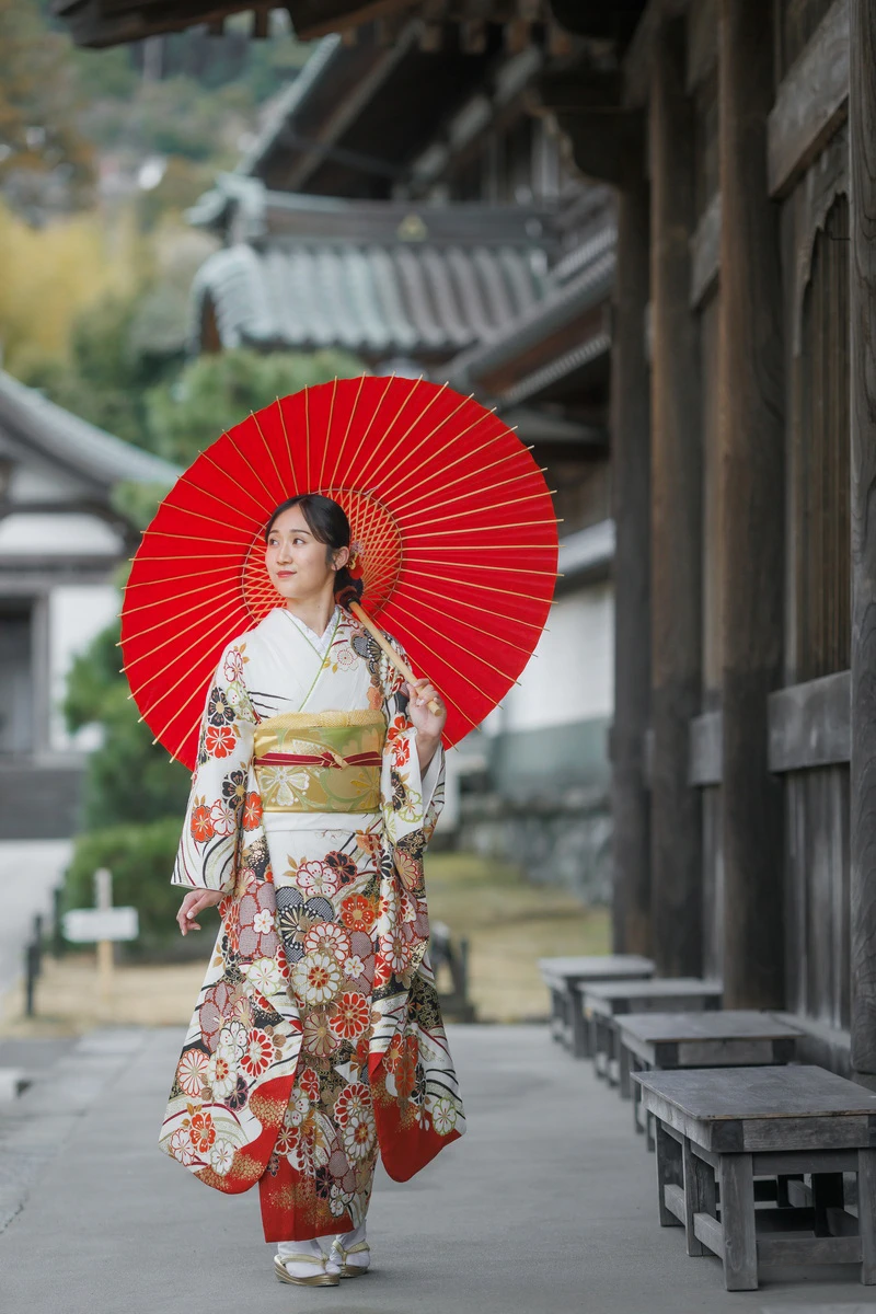 鎌倉の緑深い山奥で、色打掛の新郎新婦が印象的な階段を背景に和装前撮りを行うウェディングフォト