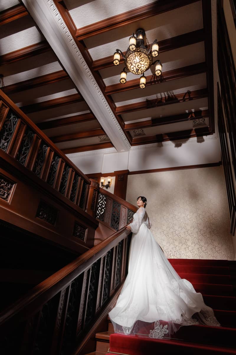 鎌倉の緑深い山奥で、色打掛の新郎新婦が印象的な階段を背景に和装前撮りを行うウェディングフォト