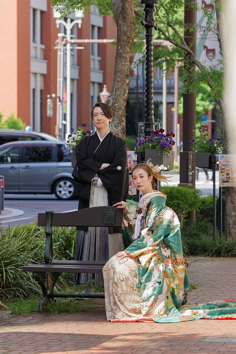 鎌倉の緑深い山奥で、色打掛の新郎新婦が印象的な階段を背景に和装前撮りを行うウェディングフォト