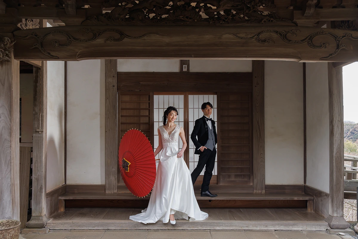赤い番傘を持つ新婦とタキシードを着た新郎が写る洋装のウェディングフォト