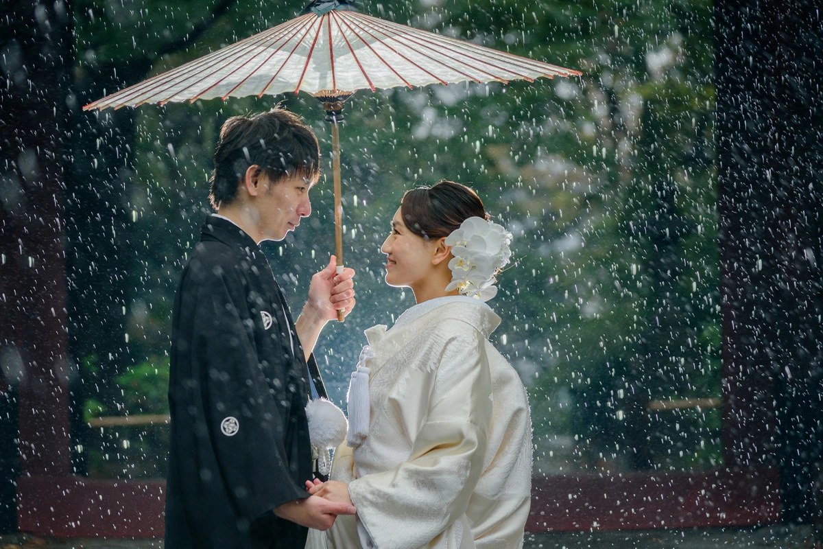 妙本寺で雨の中和装を着た新郎新婦が傘を持ち見つめ合うウェディングフォト