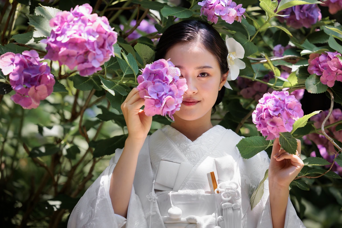 緑と紫陽花がきれいなお寺で。紫陽花と白無垢姿の新婦のアップ