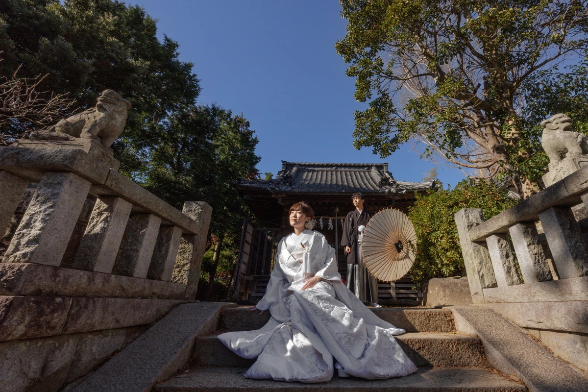 紋付き袴の新郎と白無垢綿帽子の新婦のお二人のお写真。背景の紅葉が美しい写真