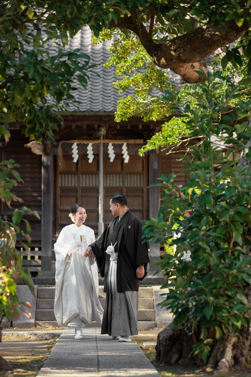 紋付き袴の新郎と白無垢綿帽子の新婦のお二人のお写真。背景の紅葉が美しい写真
