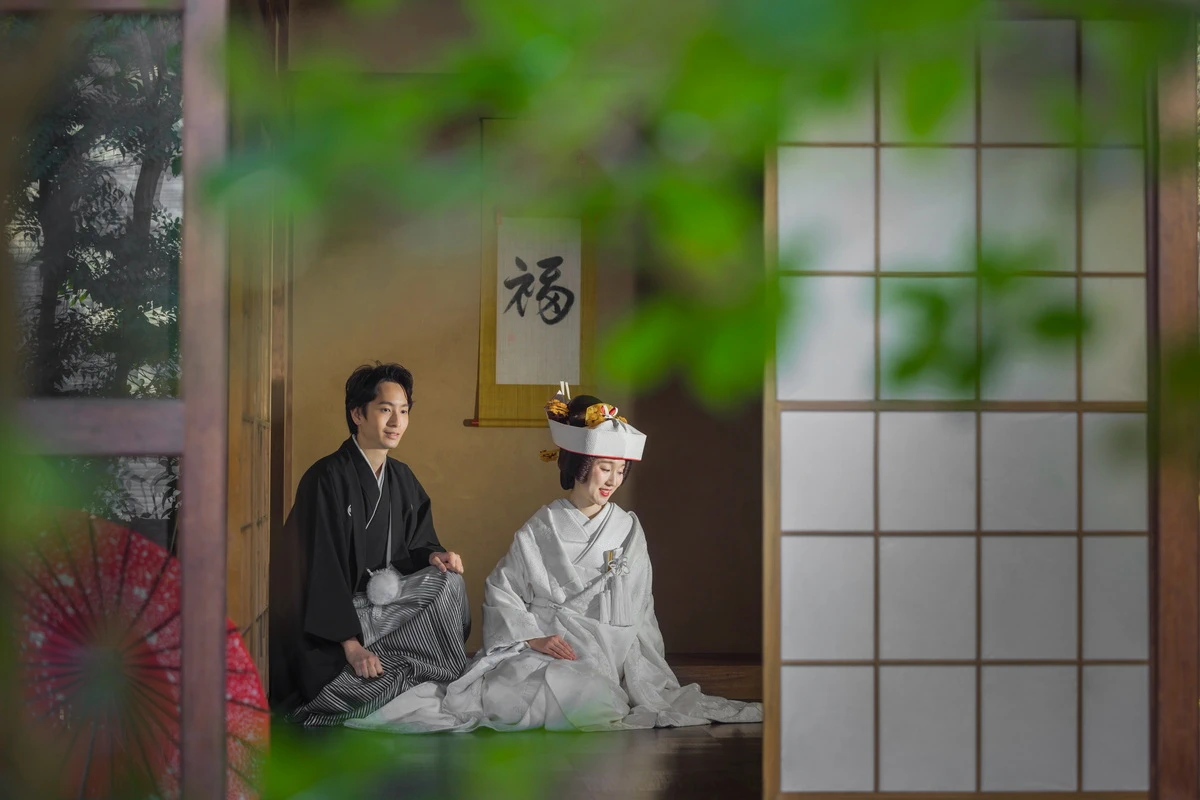 紋付き袴の新郎と白無垢綿帽子の新婦のお二人のお写真。背景の紅葉が美しい写真