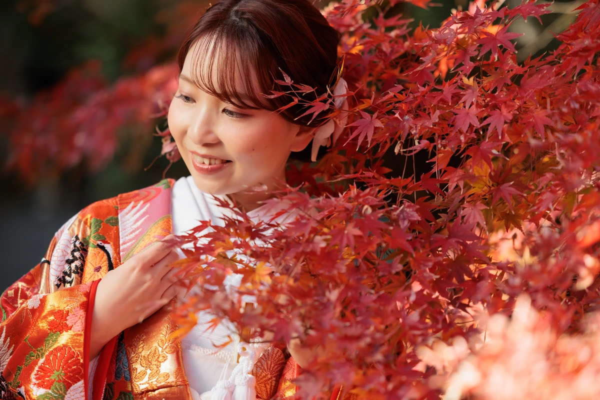 紅葉が見頃の鎌倉建長寺にて。微笑みが可愛らしい色打掛のご新婦のアップのカット