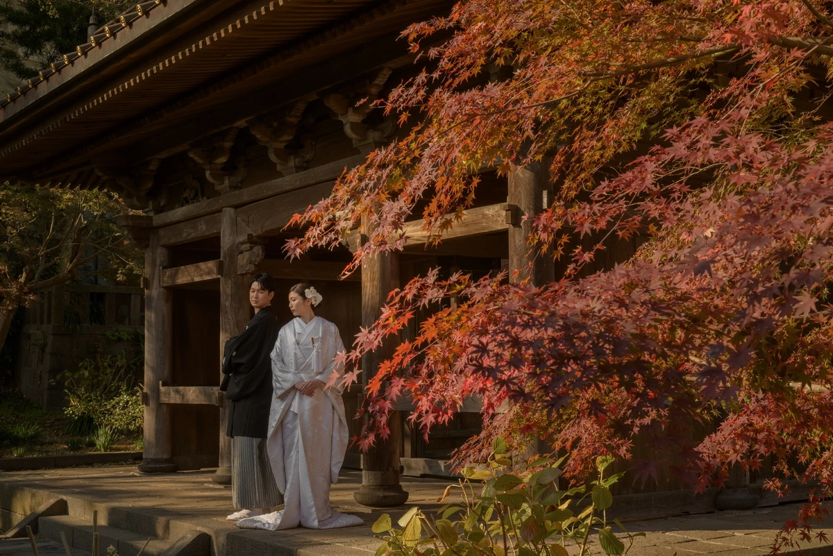 鎌倉英勝寺の紅葉と歴史ある寺院建築を背景に、白無垢姿の花嫁と紋付袴の新郎が佇む鎌倉和装前撮り・フォトウェディング