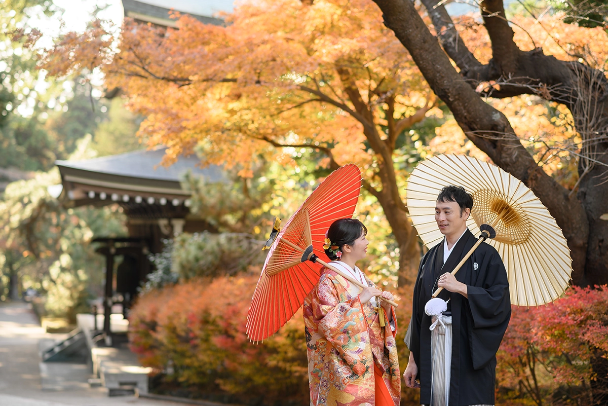 鎌倉・円覚寺の紅葉を背景に番傘を使って和装前撮りを楽しむ新郎新婦