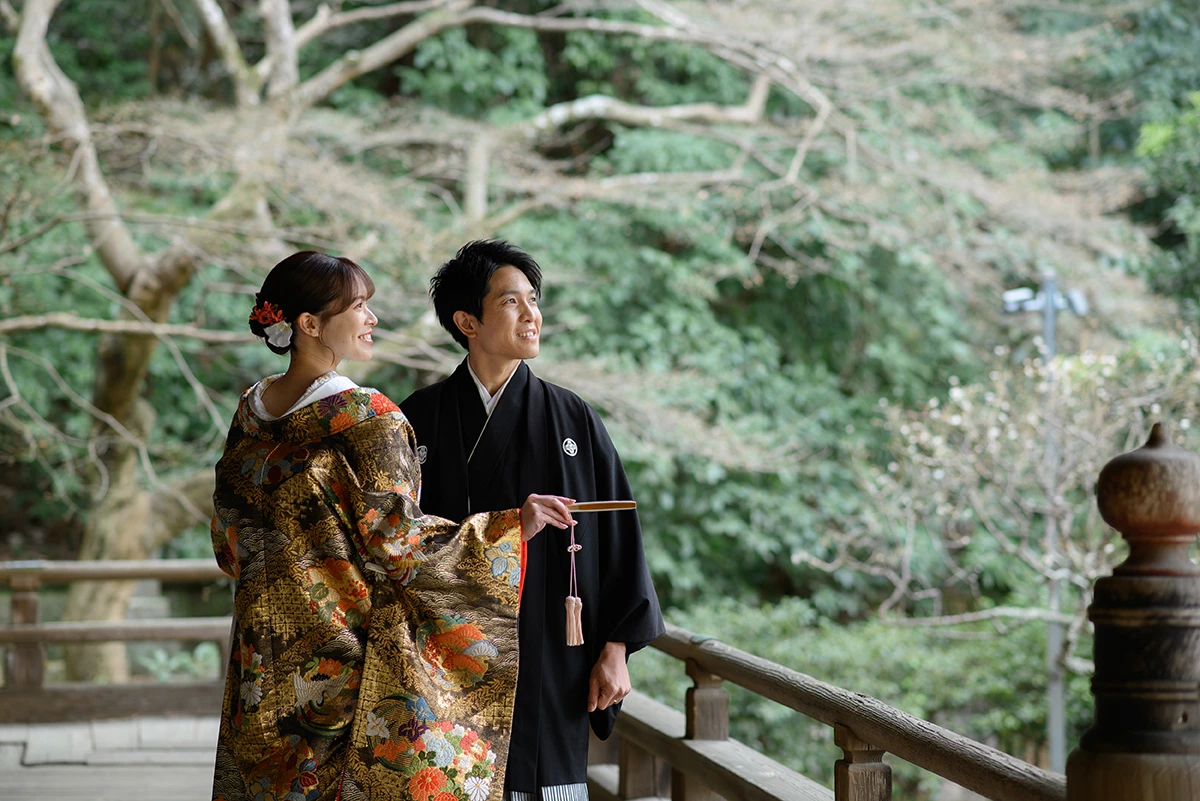 鎌倉・妙本寺で色打掛を着た新婦を紋付き袴を着た新郎が笑顔で遠くを見つめている和装フォトウェディング