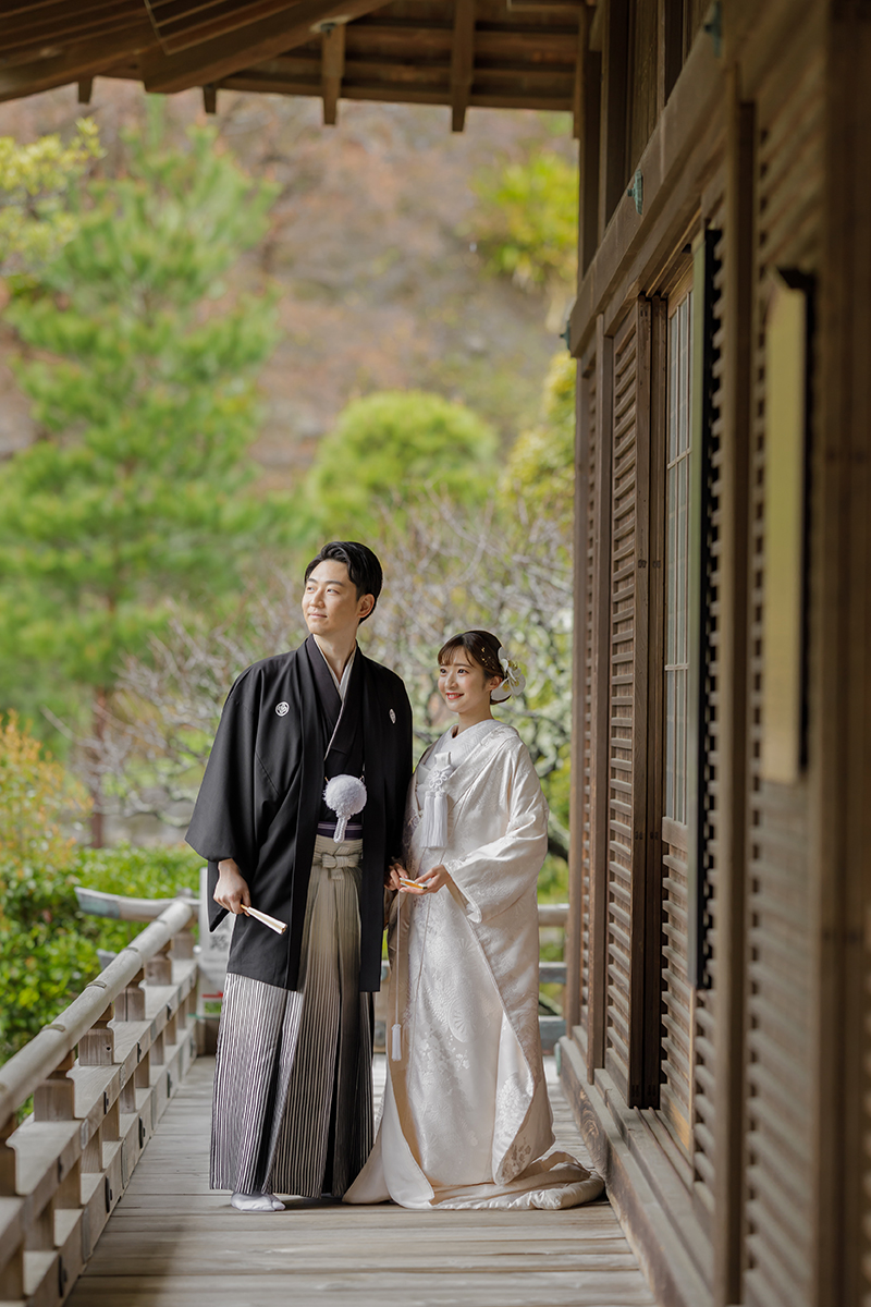 横浜・大桟橋でウェディングドレス姿とタキシード姿の新婦と新郎がみなとみらいの夜景を背景に撮影するフォトウェディング・前撮り写真