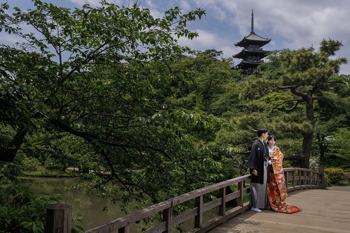 三溪園の三重塔と新緑を背景に色打掛と黒紋付姿の新郎新婦を撮影した和装前撮り写真