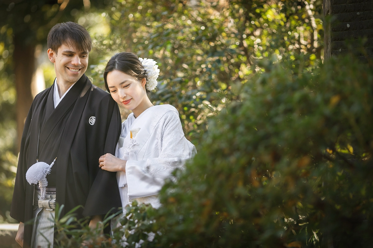 神社で寄り添う白無垢の新婦と紋付袴の新郎