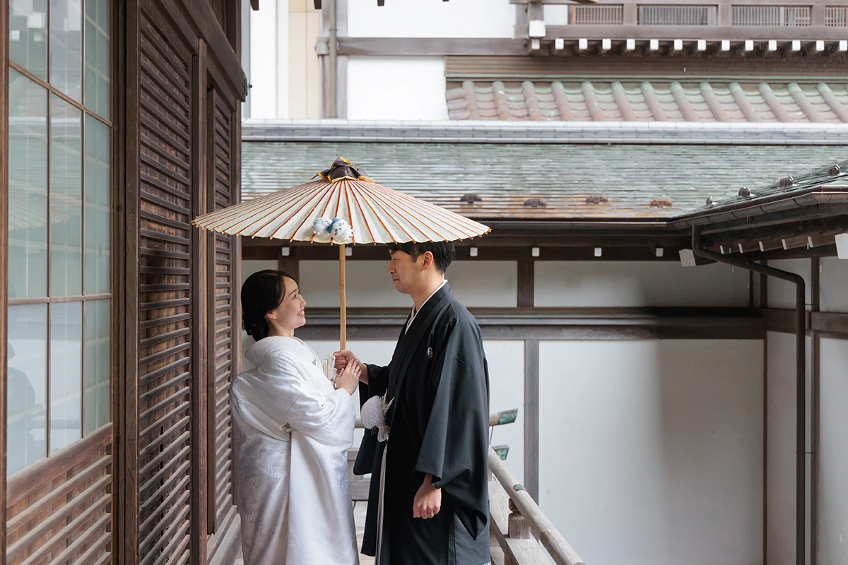 横浜・大桟橋でウェディングドレス姿とタキシード姿の新婦と新郎がみなとみらいの夜景を背景に撮影するフォトウェディング・前撮り写真
