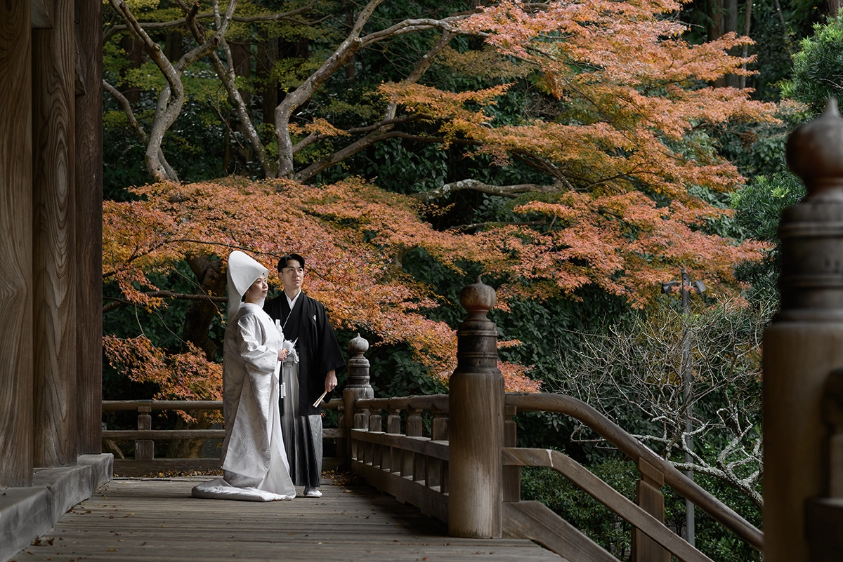 鎌倉・妙本寺の二天門前で白無垢姿の新婦と和装の新郎が紅葉に囲まれて佇むフォトウェディング・前撮り写真