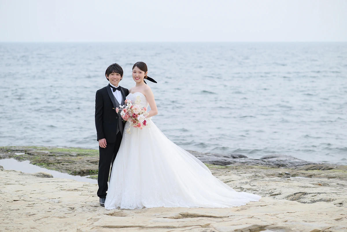 稲村ケ崎でウェディングドレスとタキシードを着用した新郎新婦が笑顔で写る洋装前撮り