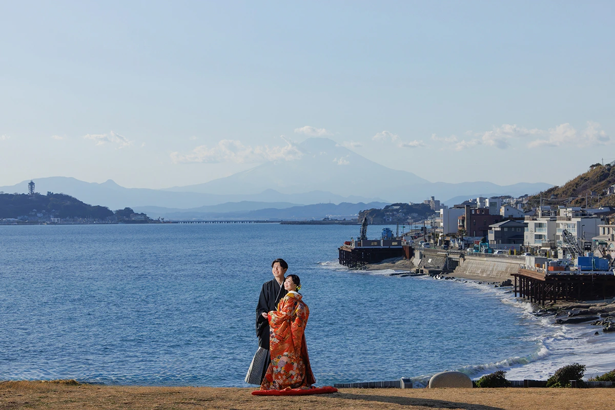 稲村ケ崎で色打掛と紋付袴を着用した新郎新婦が富士山と江ノ島を背景に写る和装前撮り