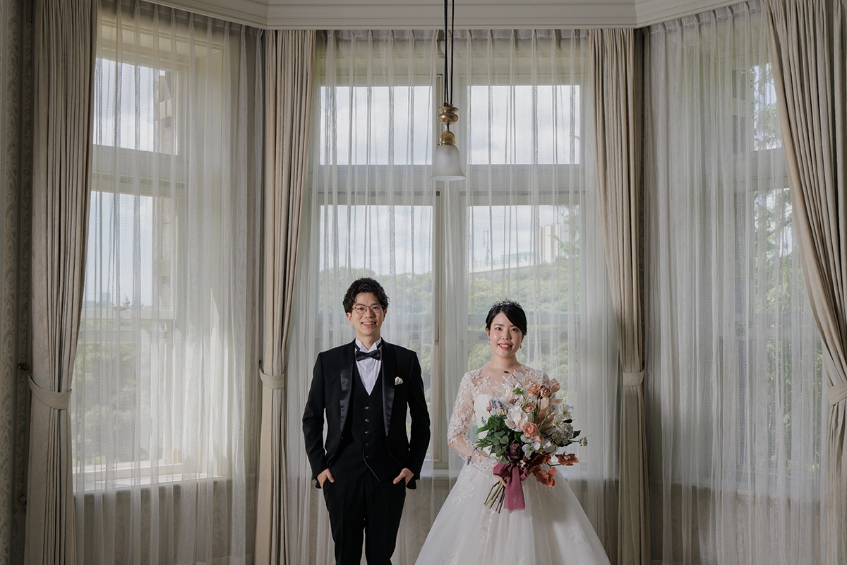 旧古河邸の大きな窓を背景に撮影した新郎新婦のウェディングフォト