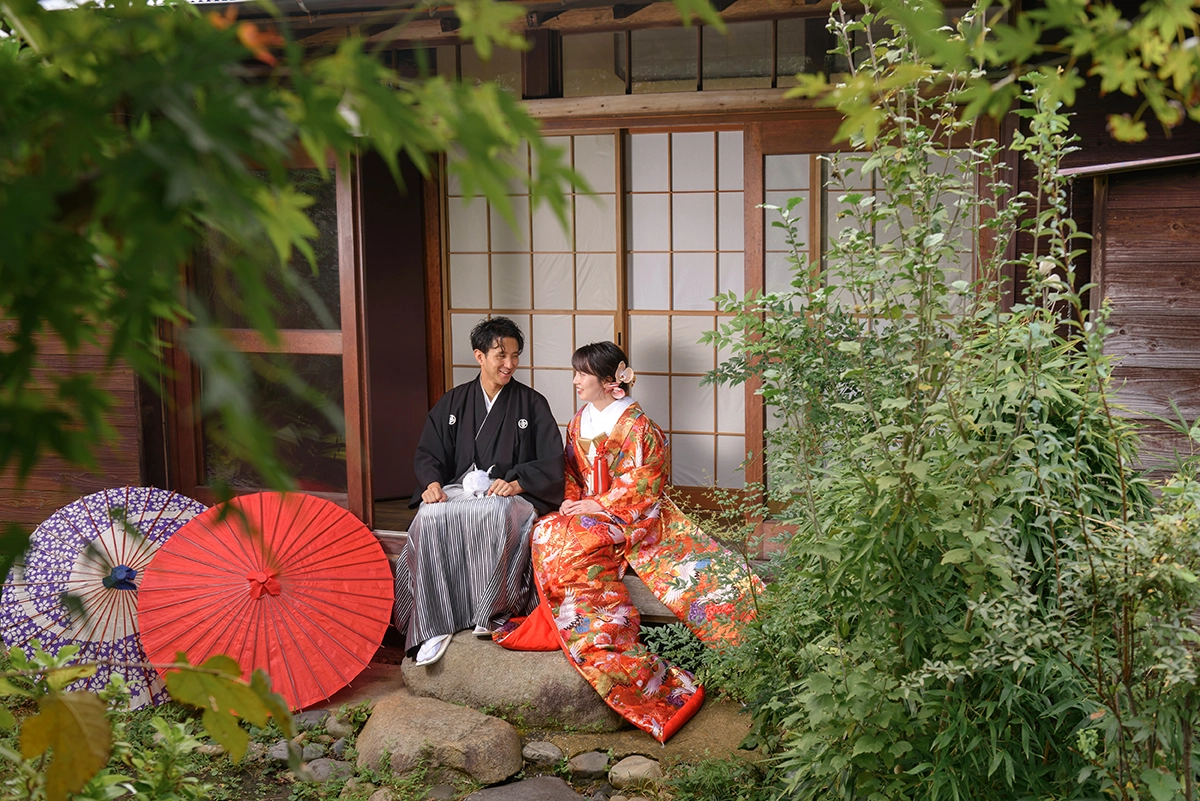 お寺で正座する色打掛と黒紋付袴の新郎新婦