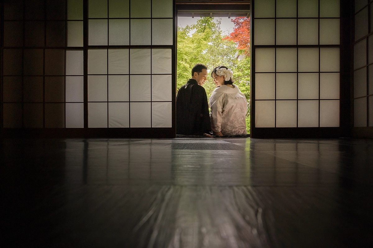 神社で寄り添う白無垢の新婦と紋付袴の新郎