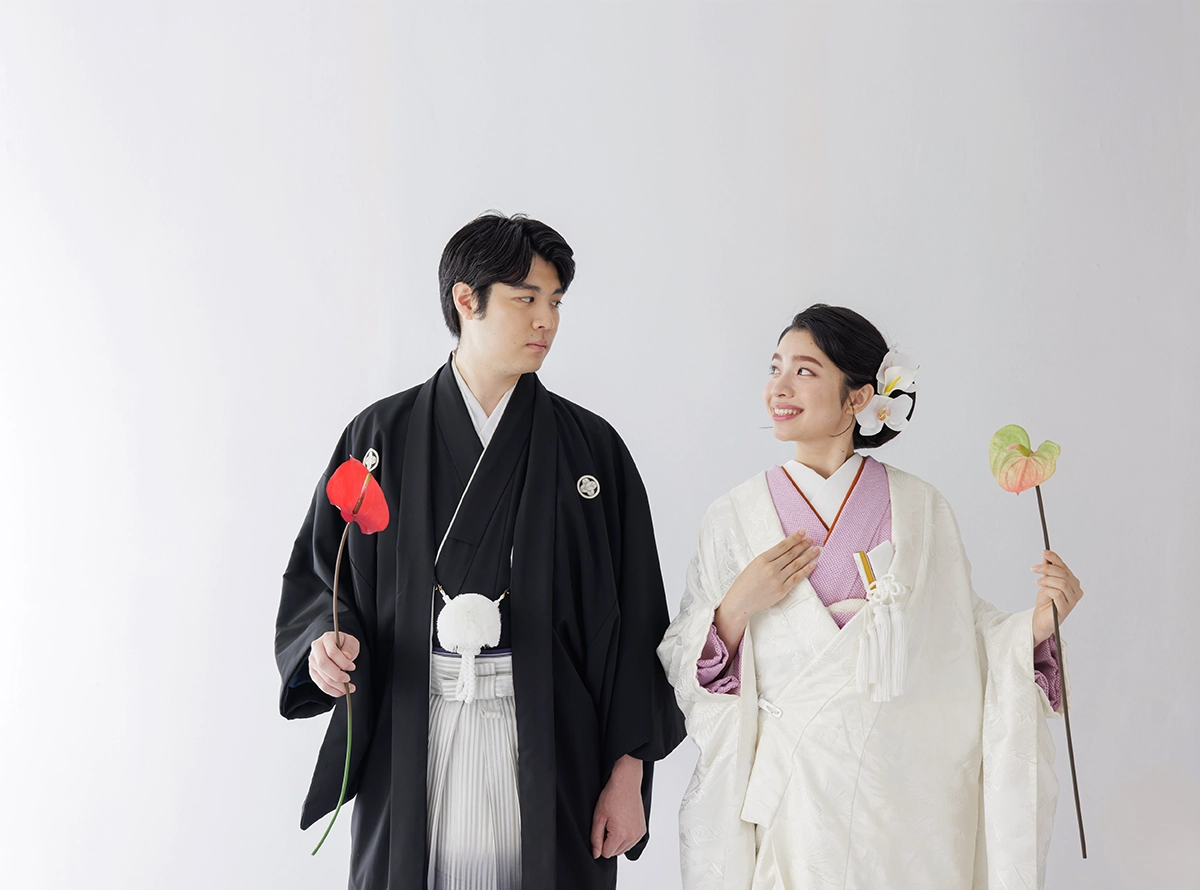 お寺で正座する色打掛と黒紋付袴の新郎新婦