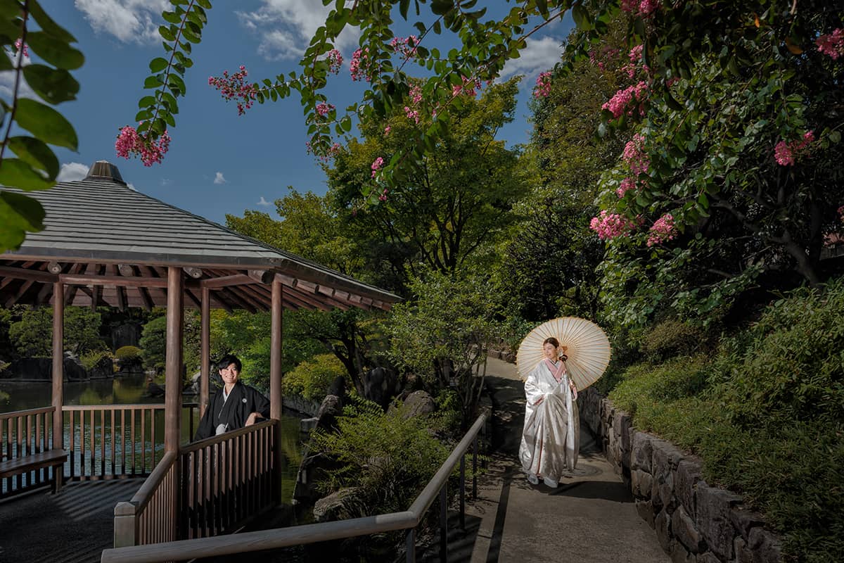 横浜・大桟橋でウェディングドレス姿とタキシード姿の新婦と新郎がみなとみらいの夜景を背景に撮影するフォトウェディング・前撮り写真