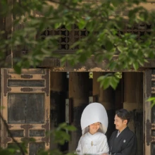 鎌倉 和洋装 H様・S様 2021.06.15 建長寺の木造建築の入口で、綿帽子と白無垢姿の新婦に黒紋付袴の新郎が寄り添う鎌倉フォトウェディング