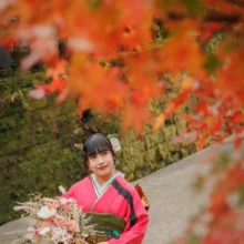 成人式撮影 S様 2022.12.03 秋の建長寺で、赤く色づいた紅葉に囲まれながらブーケを持つ、赤と黒の振袖姿の女性