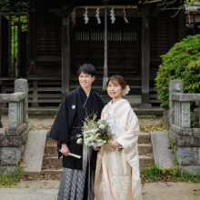 鎌倉・鎌倉本店の隣の神社で春に撮影した和装前撮り 鎌倉・鎌倉本店の隣の神社で白無垢を着用した新婦と紋付袴を着用した新郎が笑顔で遠くを見ている和装前撮り