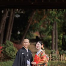 横浜・三渓園で秋に撮影した和装前撮り 横浜・三渓園で色打掛を着用した新婦と紋付袴を着用した新郎が遠くを見つめてほほ笑む和装前撮り