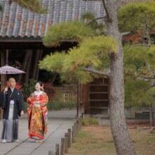 横浜・三渓園で秋に撮影した和装前撮り 横浜・三渓園で色打掛を着用した新婦と紋付袴を着用した新郎が番傘を持ち歩く和装前撮り