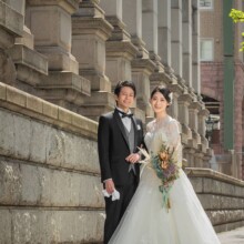 横浜・馬車道で春に撮影した洋装前撮り 横浜・馬車道でウェディングドレスを着用した新婦とタキシードを着用した新郎がブーケを持って写る洋装ウェディングフォト