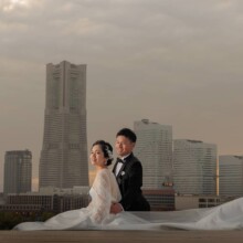 横浜・大桟橋で春に撮影した洋装前撮り 横浜・大桟橋でウェディングドレスを着用した新婦とタキシードを着用した新郎が座って写る洋装前撮り