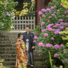 鎌倉・妙法寺で夏に撮影した和装前撮り 鎌倉・妙法寺で色打掛を着用した新婦と紋付袴を着用した新郎が階段で紫陽花と一緒に写る和装ウェディングフォト