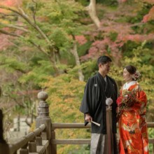 鎌倉・妙本寺で秋に撮影した和装前撮り 鎌倉・妙本寺で色打掛を着用した新婦と紋付袴を着用した新郎が見つめ合ってほほ笑んで写る和装ウェディングフォト