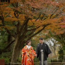 鎌倉・妙本寺で秋に撮影した和装前撮り 鎌倉・妙本寺で色打掛を着用した新婦と紋付袴を着用した新郎が手を繋いで歩いている和装ウェディングフォト