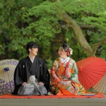 鎌倉・妙本寺で春に撮影した和装前撮り 鎌倉・妙本寺で色打掛を着用した新婦と紋付袴を着用した新郎が正座をして見つめ合ってほほ笑む和装前撮り