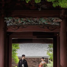 鎌倉・妙本寺で夏に撮影した和装前撮り 鎌倉・妙本寺で色打掛を着用した新婦と紋付袴を着用した新郎が赤門の前で見つめ合ってほほ笑む和装前撮り