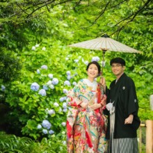 鎌倉・妙本寺で夏に撮影した和装前撮り 鎌倉・妙本寺で色打掛を着用した新婦と紋付袴を着用した新郎が番傘の中で笑顔で写る和装前撮り