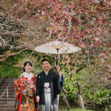 鎌倉・英勝寺で春に撮影した和装前撮り 鎌倉・英勝寺で色打掛を着用した新婦と紋付袴を着用した新郎が番傘を持ち写っている和装ウェディングフォト