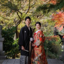 鎌倉・妙本寺で秋に撮影した和装前撮り 鎌倉・妙本寺で色打掛を着用した新婦と紋付袴を着用した新郎がこちらを見てほほ笑む和装前撮り