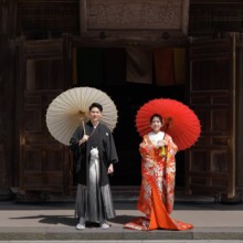 鎌倉・建長寺で春に撮影した和装前撮り 鎌倉・妙本寺で色打掛を着用した新婦と紋付袴を着用した新郎が番傘を持って写る和装前撮り