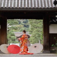 横浜・三渓園で春に撮影した和装前撮り 横浜・三渓園で色打掛を着用した新婦が扇子を持ち後ろ姿で写る和装前撮り