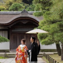 横浜・三渓園で春に撮影した和装前撮り 横浜・三渓園で色打掛を着用した新婦と紋付袴を着用した新郎が手を取り歩く和装前撮り