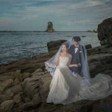 富山で夏に撮影した洋装前撮り 富山でウェディングドレスを着用した新婦とタキシードを着用した新郎がベールをかぶって写る洋装フォトウェディング