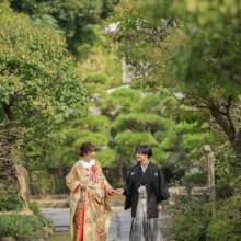 秋に撮影した和装前撮り 色打掛を着用した新婦と紋付袴を着用した新郎が手を取って歩いている和装前撮り