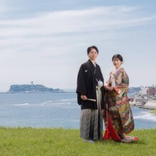 鎌倉・稲村ガ崎で春に撮影した和装前撮り 鎌倉・稲村ガ崎で色打掛を着用した新婦と紋付袴を着用した新郎が江ノ島を背景に写る和装前撮り