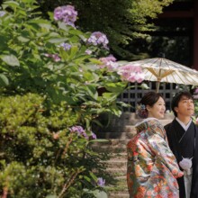 鎌倉・妙法寺で夏に撮影した和装前撮り 鎌倉・妙法寺で色打掛を着用した新婦と紋付袴を着用した新郎が番傘を持ち遠くを見つめている和装ウェディングフォト
