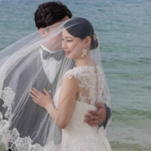 沖縄本島で秋に撮影した洋装前撮り 沖縄本島でウェディングドレスを着用した新婦とタキシードを着用した新郎がベールをかぶって写る洋装ウェディングフォト
